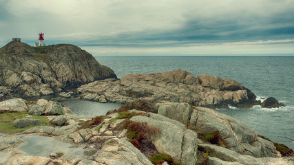 Norway landscape south lighthouse Lindesnes fyr on the rocky shore of the northern sea in cloudy weather - obrazy, fototapety, plakaty
