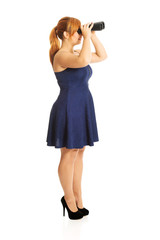 Businesswoman looking in binoculars. Finding vision or spying on competition.