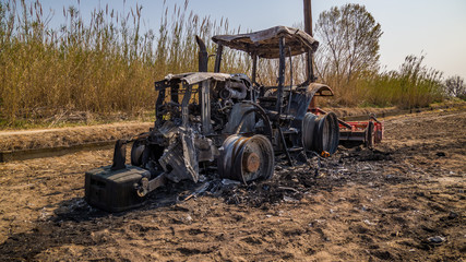 abandoned burned tractor in field