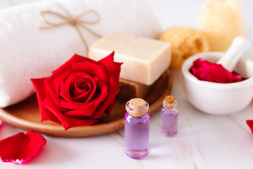 Spa product with rose oil and .Rose petals on white background.