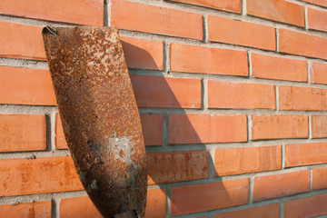 spade shovel on red brick wall