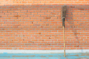 wooden broomstick  on red brick wall