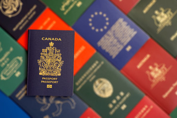 Canada biometric passport on a blurred background of passports of many countries of the world