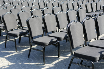 Rows of gray chairs. Street concert, conference, presentation.