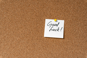 Good luck! Handwritten inspirational supportive lettering on a sticker on a cork board. Background...
