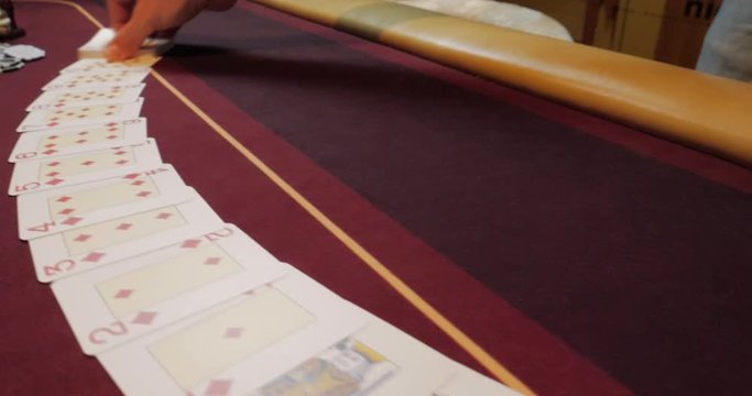 Casino: Dealer man shuffles the poker cards and performing trick with cards