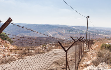 Barbed wire fence enclosing the village Peduel in the Samaria region in Benjamin district in Israel - obrazy, fototapety, plakaty
