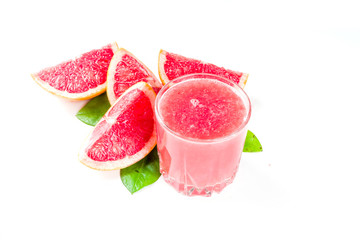 Glass of grapefruit juice with whole and sliced grapefruit isolated on white background