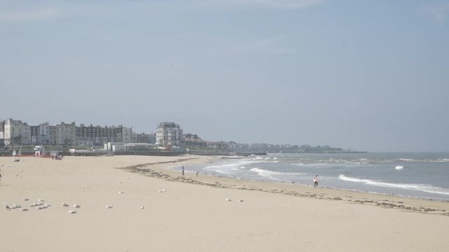Margate beach with people walking by the sea