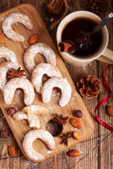 Fototapeta premium Cookies in a shape of horseshoe covered with sugar powder. Delicious biscuits with almonds and hazelnuts. Sweet Christmas dessert.