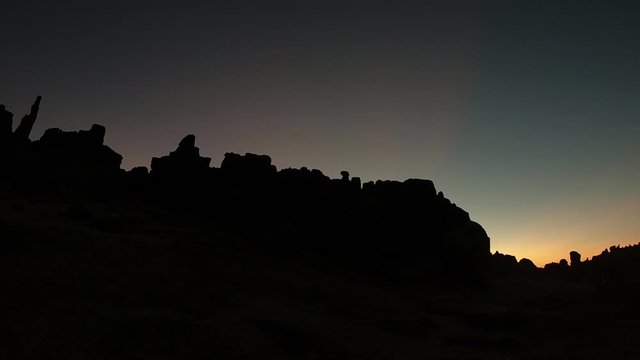 Sunrise at a peruvian stone forest. Backlight silhouette panning shot.