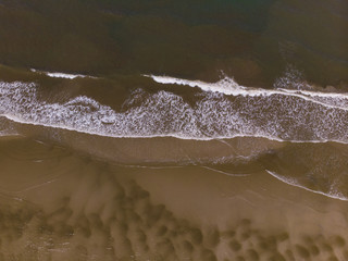 Aerial drone image view of ocean waves crashing on beach 