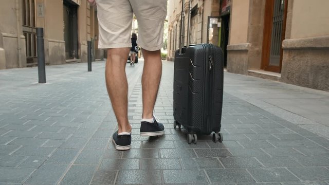 Close up on lower or bottom part of business man leg walking forward with blue baggage on the skytrain station. Business, travel, transportation and outdoor concept with tourist student