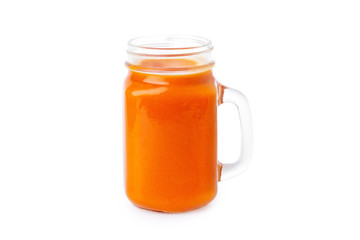 Closeup glass jar of orange color smoothie isolated at white background. Concept of healthy vegan food