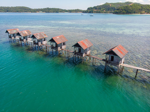 Aerial drone view of abandoned houses on  Beautiful white sandy beach with turquoise sea water and palm trees at Kuala Abai, Kota Belud, Sabah, Borneo