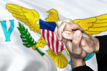 United States Virgin Islands flag and praying patriot man with crossed hands. Holding cross, hoping and wishing.
