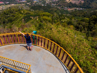 A young lady happy and enjoying a beautiful landscape and fresh air at Sinurambi Tower, Tambunan,...