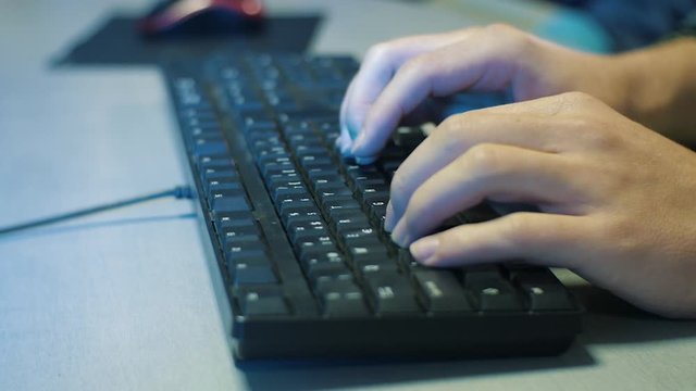 Man's hands typing on PC keyboard in the office. Evening time, static shot, keyboard on the gray desk, Man fast typing close up