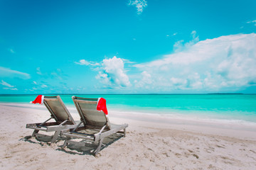 Christmas on beach -chair lounges with Santa hats at sea