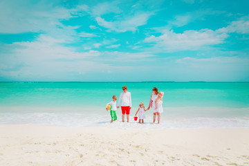 Fototapeta na wymiar happy family with three kids walk on beach