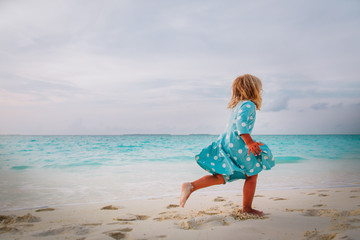 happy little girl run and play on tropical beach