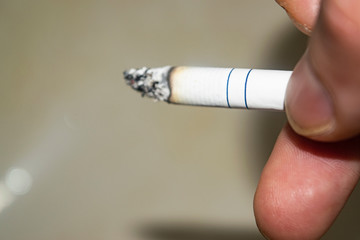 Cigarette in a man's hand concept photo. The dangers of Smoking. Healthy lifestyle. Rejection of bad habits.