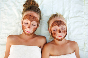 Beautiful girls with facial mask coffee scrub. Top view.