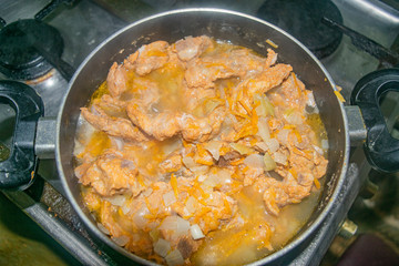 Meat with onions and carrots stewed in a saucepan. Home cooking.