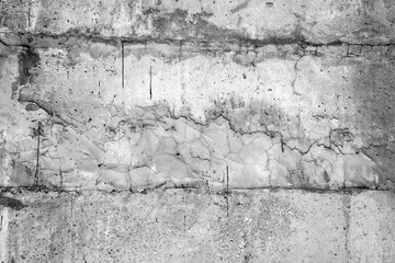Gray wall covered with an uneven rough layer of plaster with holes, irregularities, cracks and thin traces of flowing black resin