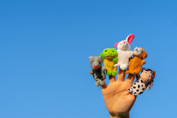 child hand with finger dolls: cow, frog, dog, rabbit, mouse, hare. animal finger puppets show and...