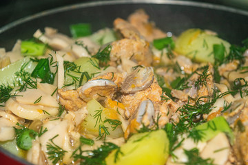 Meat with onions, carrots, potatoes, dill and Bay leaf is stewed in a saucepan. Home cooking. Close up.