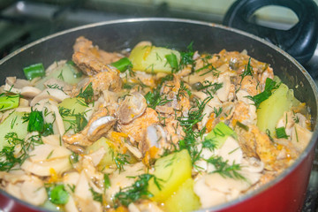 Meat with onions, carrots, potatoes, dill and Bay leaf is stewed in a saucepan. Home cooking. Close up.