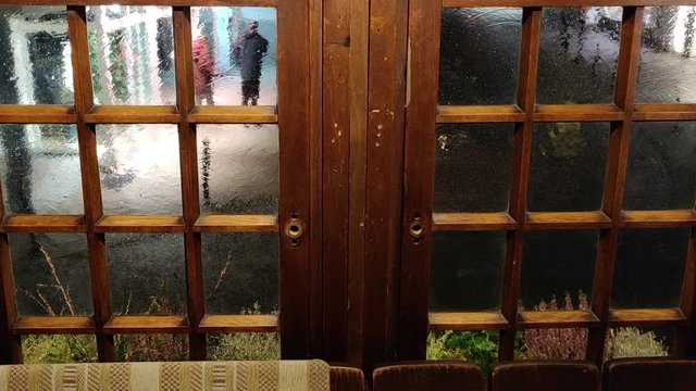 People walking through the downtown area of Ratingen, Germany, seen from behind the window of a restaurant.