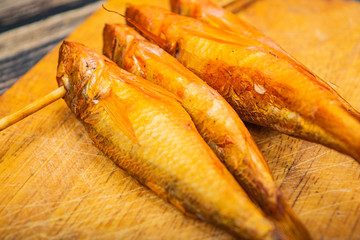 Dried mullet on a wooden Board on the table. Fish and seafood cuisine. Tasty snack. Close up.