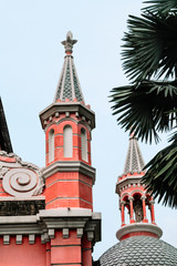 Fototapeta na wymiar Close up of Tan Dinh church exterior with steeple and red wall against the blue sky in Ho Chi Minh city, Vietnam