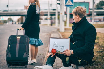 separation of man and woman. girl with a suitcase leaves the guy. young man upset