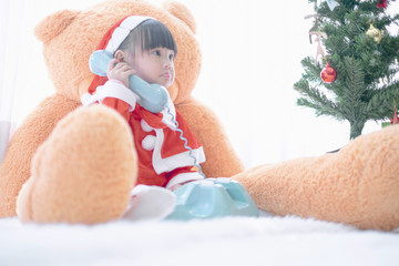 Obraz na płótnie Canvas Merry christmas happy little child in santa red hat with Big teddy bear holidays in home, christmas concept