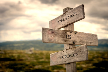 Change is good quote on wooden signpost in nature with moody background. Motivational, move on,...