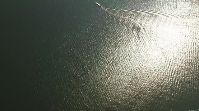 Aerial of boat along coast of shimmering lake, West Java, Truck Right