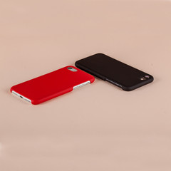 Black and red cell phones in case on pink background