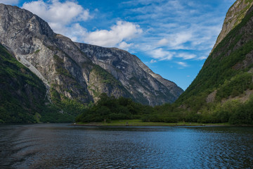 Mountains and Neroyfjord Sognefjord in Norway. Clouds and blue sky. July 2019