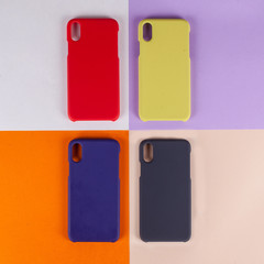 Cell phone cases various colors on multicolor paper background