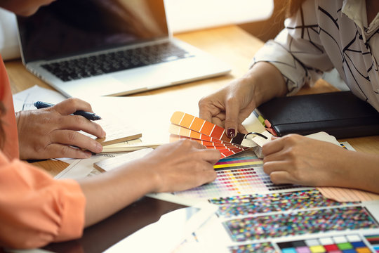 The designer team is meeting to select various colors and raw materials in product design.