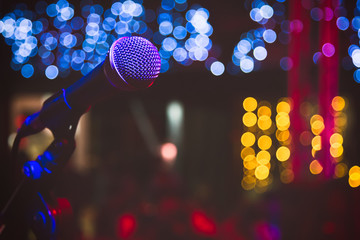 Close up of microphone in concert hall or conference room. Microphone on stage with colorful...