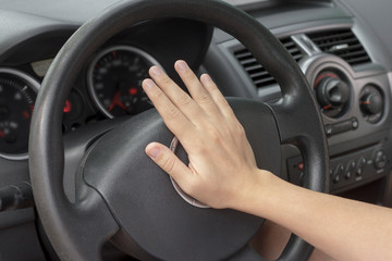 Women driver pushing the horn of the car