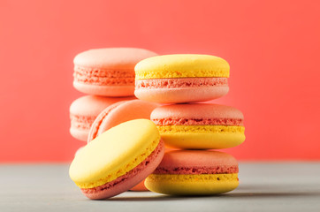Pink yellow macaroons on soft pink background table, place for text, minimalism style