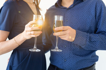 Close-up of man and woman celebrating Christmas or New Year eve party with glasses of champagne.