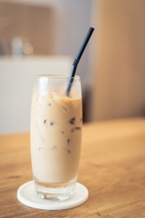 Iced coffee serve on glass with plastic tube, put on wooden table