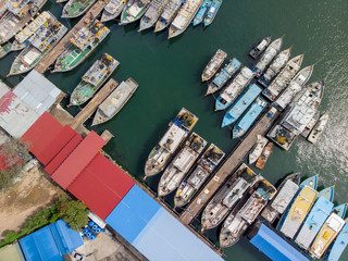 Aerial image of local lifestyle fisherman boat parking at fresh seafood market jetty at Kudat, Sabah, Malaysia.