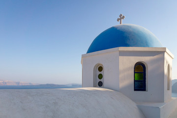 Fototapeta na wymiar Blue roofed church dome in the islands of santorini in greece. Sunset, blue hour, colors, view, religion, architecture, building, travel, summer, holiday concept.